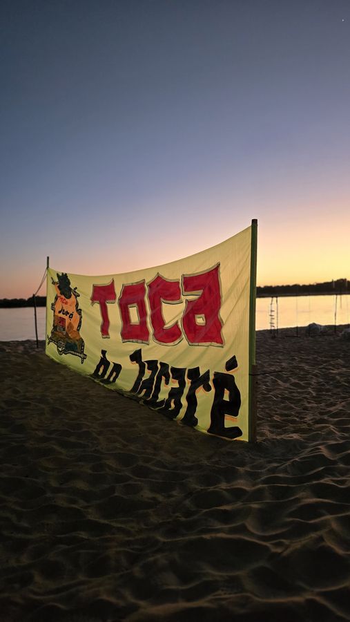 A faixa da Toca fincada na areia — acampamento Toca do Jacaré, Rio Araguaia